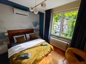 a bedroom with a bed and a large window at Rudy Kot in Gdańsk