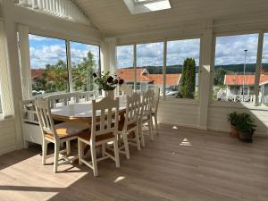 a white dining room with a table and chairs at House close to the forest and the lake in Huskvarna +9 photos