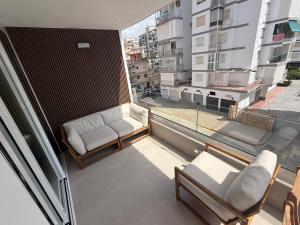 a balcony with two chairs and a large window at Beach Apartment in Torre del Mar in Torre del Mar