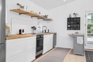 a kitchen with white cabinets and black appliances at 30192-Malling-Askvaenget-13 in Malling