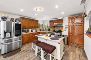a kitchen with wooden cabinets and stainless steel appliances at Casa Sur in Chula Vista