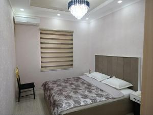 a bedroom with a bed and a chair and a chandelier at comfort house in Khiva