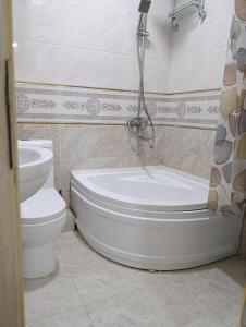 a bathroom with a bath tub and a toilet at comfort house in Khiva