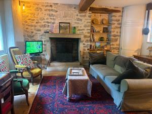 a living room with a couch and a fireplace at Chez Katia in Semur-en-Auxois