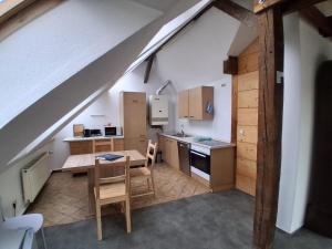 an attic kitchen with a wooden table and chairs at Mittendrin in Stendal