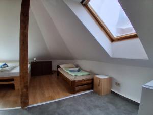 a attic room with two beds and a window at Mittendrin in Stendal +2 photos