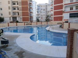 a swimming pool in an apartment with buildings at Beach Apartment in Torre del Mar in Torre del Mar