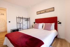 a bedroom with a large bed with a red headboard at Latitude Guest House in Cantanhede +80 photos