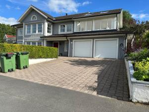 a house with two garage doors on a brick driveway at House close to the forest and the lake in Huskvarna
