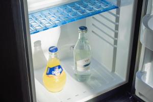 two bottles of soda and water in an open refrigerator at Hotel Villa Nord Hamburg-Airport in Hamburg
