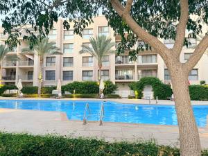 a swimming pool in front of a building at Condo in Marassi Marina in El Alamein