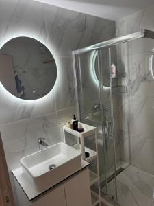 a white bathroom with a sink and a shower at Calliroe Sea View in Alexandroupoli