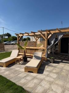 a patio with two lounge chairs and a wooden pergola at Calliroe Sea View in Alexandroupoli
