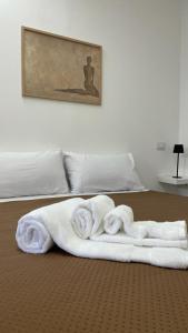 a pile of towels on top of a bed at Maiori Vacation Home in Cinisi +40 photos