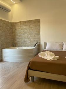 a bedroom with a bed and a bath tub at Maiori Vacation Home in Cinisi