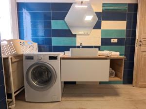 a laundry room with a washing machine and a sink at La casa di venera in Bacoli