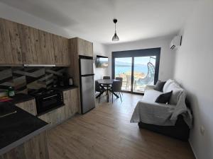 a kitchen and living room with a couch and a table at Episkopos Escape in Nikiana