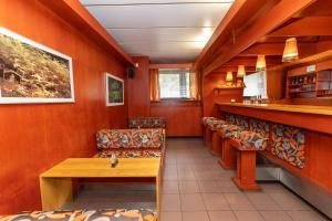 a restaurant with orange walls and chairs and a bar at hotel Černá Bouda in Janske Lazne