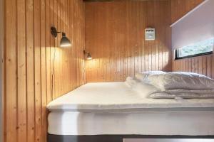 a bed in a room with a wooden wall at M404-Gedser-Frede-Buchsvej-3 in Gedser
