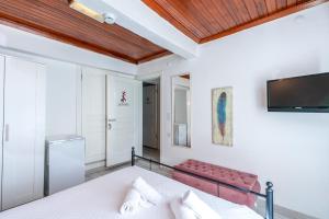 a bedroom with a bed and a tv on the wall at İmerek Taş Ev Otel Alaçatı in Alaçatı