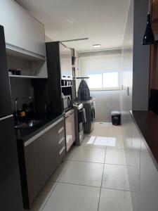 a kitchen with black and white counters and appliances at Flat Red Sorocaba - Blue in Sorocaba