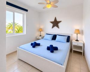 a bedroom with a bed with two blue pillows on it at Casa Sol de Jandía in Morro del Jable +24 photos