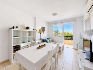 a white dining room with a white table and chairs at Casa Sol de Jandía in Morro del Jable