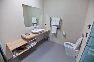 a bathroom with a sink and a toilet and a mirror at Waterfront Apartments in Devonport