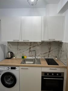 a kitchen with white cabinets and a sink and a dishwasher at Xenia's Resorts in Ofrínion