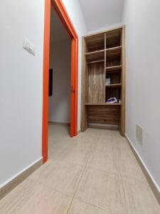 an empty hallway with an orange door and a closet at Villa Shtëpia në Pyll in Draç