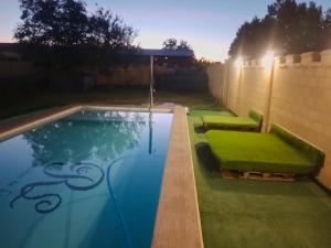 a swimming pool with a green lawn in a backyard at Remedios de Luna in Antimio de Arriba
