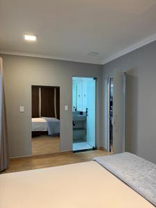 a bedroom with a bed and a bathroom at Flat Red Sorocaba - Blue in Sorocaba +29 photos
