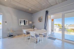 a dining room with a white table and chairs at Meraki Sands in Hermanus