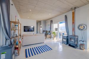 a living room with a couch and a stove at Meraki Sands in Hermanus