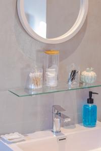 a bathroom with a glass shelf above a sink at Meraki Sands in Hermanus +34 photos