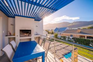a blue table on a balcony with a view at Meraki Sands in Hermanus