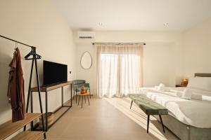 a bedroom with a bed and a flat screen tv at Ormos Piraeus in Piraeus