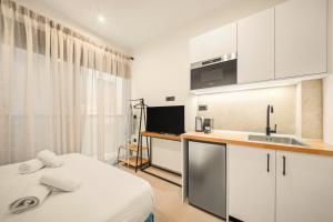 a bedroom with a bed and a kitchen with a sink at Ormos Piraeus in Piraeus