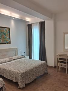 a hotel room with two beds and a window at Hotel Flora in Alba Adriatica