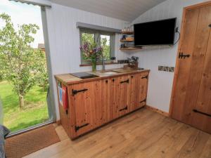 a kitchen with a sink and a tv on a wall at Bramleys in Taunton +5 photos