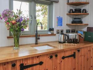 a kitchen counter with a vase of flowers on it at Bramleys in Taunton