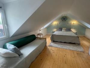 a attic bedroom with a bed and two rugs at Dove Cottage Chatka 35 Chalmová in Bystričany