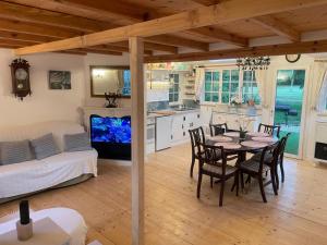 a kitchen and living room with a table and chairs at Dove Cottage Chatka 35 Chalmová in Bystričany