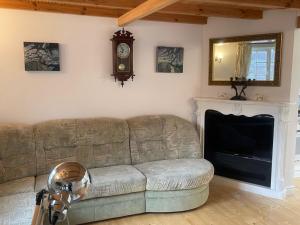 a living room with a couch and a clock on the wall at Dove Cottage Chatka 35 Chalmová in Bystričany