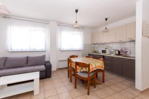 a kitchen and dining room with a table and a couch at Apartmants 38 in Pag