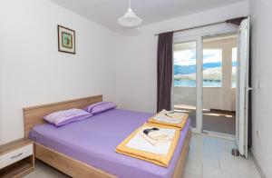 a bedroom with a bed with a view of the ocean at Apartmants 38 in Pag