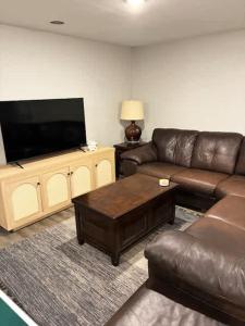 a living room with a couch and a flat screen tv at CrossLake Getaway in Cross Lake