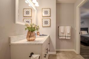 a bathroom with a vase of flowers on a counter at CrossLake Getaway in Cross Lake +39 photos