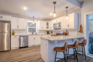 a kitchen with white cabinets and stainless steel appliances at CrossLake Getaway in Cross Lake