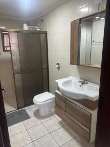 a bathroom with a toilet and a sink and a shower at Apartamentos nadai apto 202 in Foz do Iguaçu +40 photos